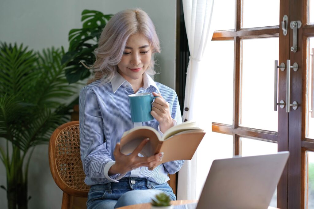 woman reading a book and drinking coffee