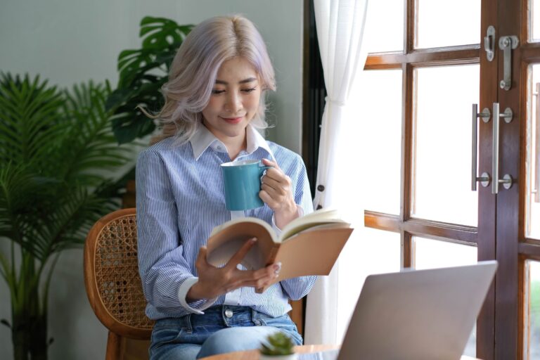 woman reading a book and drinking coffee