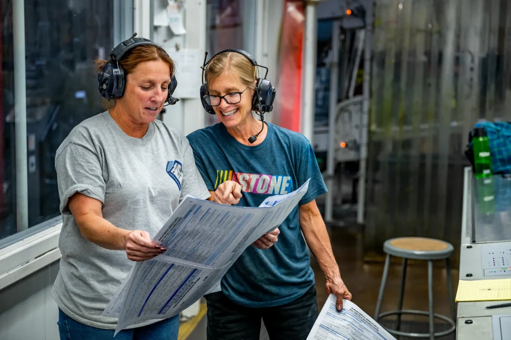 Lakeside employees performing a quality control check on sensitive printed materials in a secure manufacturing environment.
