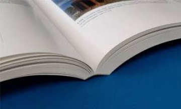 Close-up of the square spine of a perfect-bound softcover book, showing the clean, flat edge where the cover is glued to the internal pages.