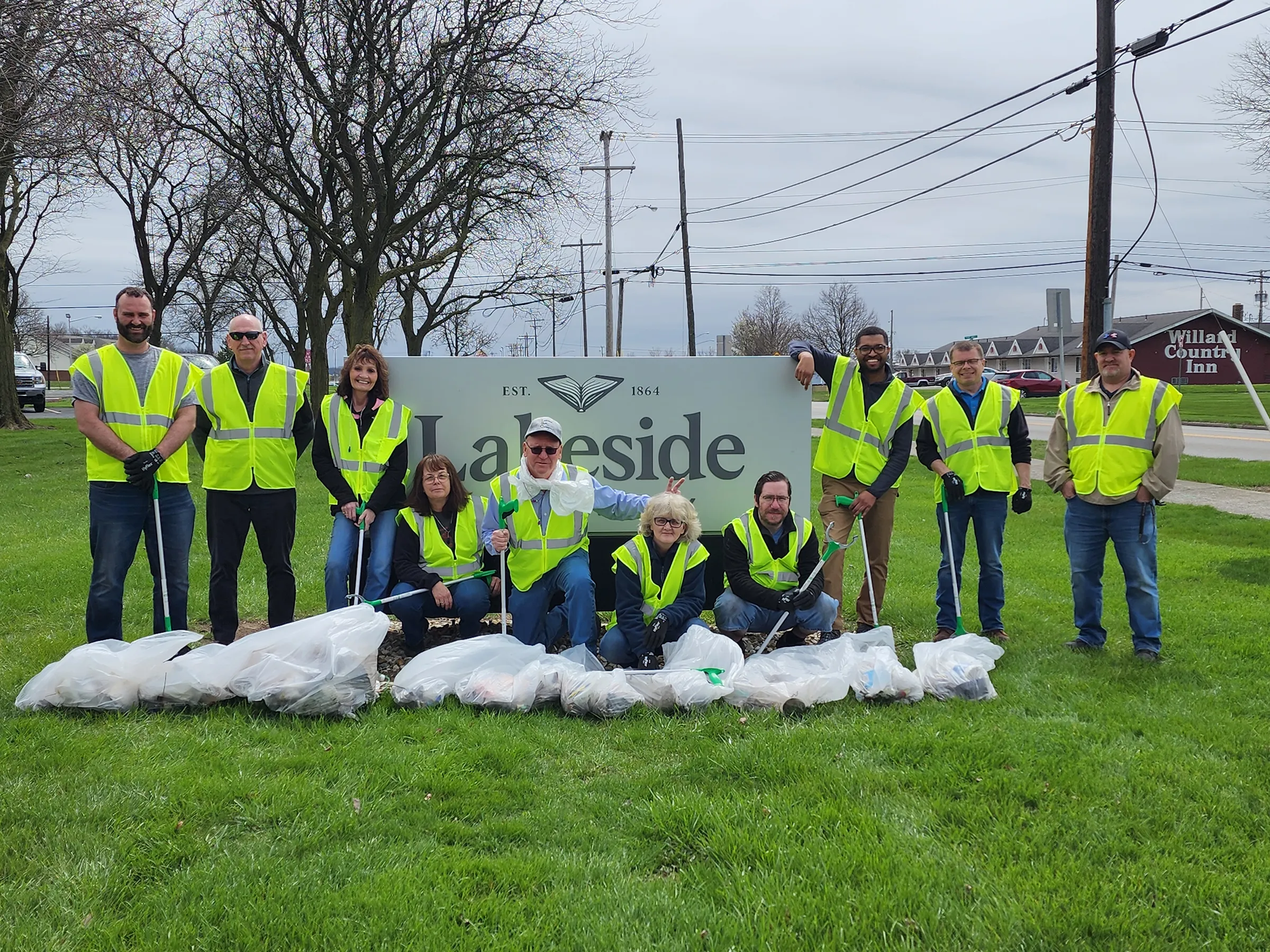 Lakeside Book Company employees wearing high-visibility safety vests during a community environmental cleanup event.